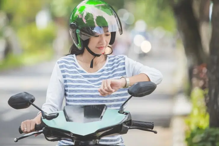 En kvinne som kjører motorsykkel i hjelm